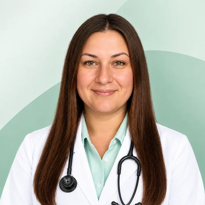 A smiling woman with long brown hair in a white coat over a mint shirt, a stethoscope around her neck
